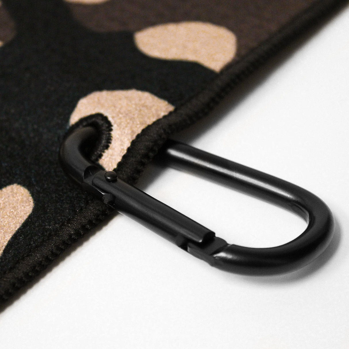 Close up of Utility Towel black carabiner clip with 'Camo' graphic