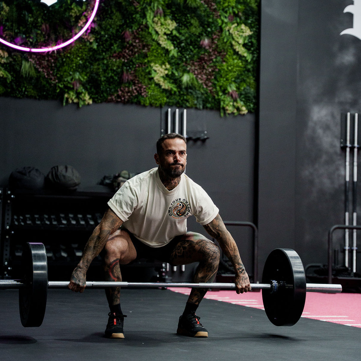 Male model weightlifting in a gym wearing Street Tee with 'Excuses or Reasons' graphic