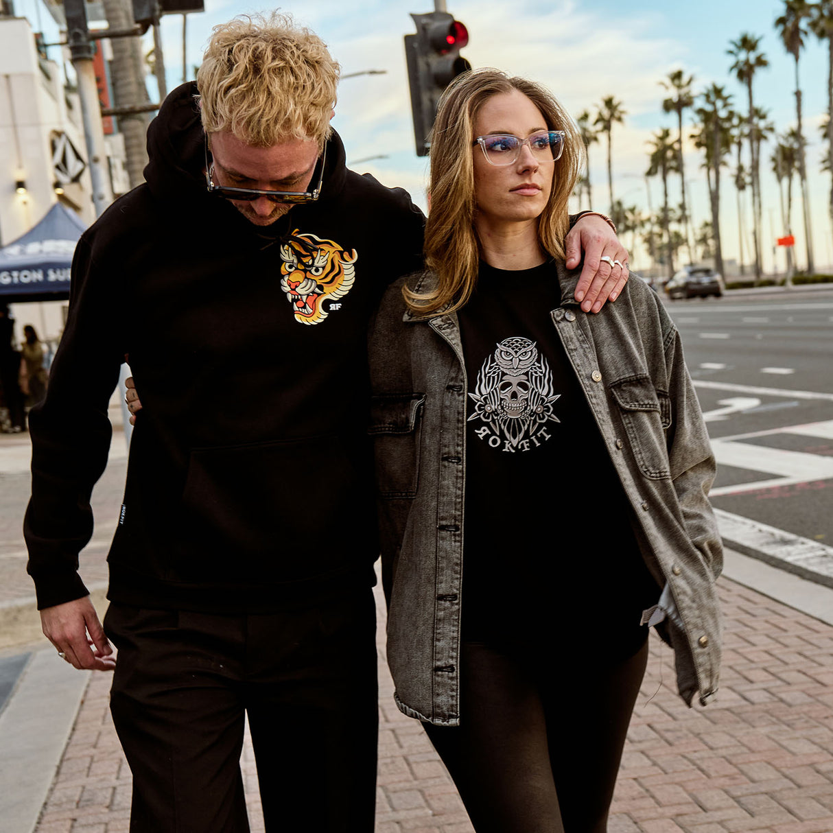 Male and Female models outdoors wearing hoody with 'Make Excuses or Make Progress' graphic