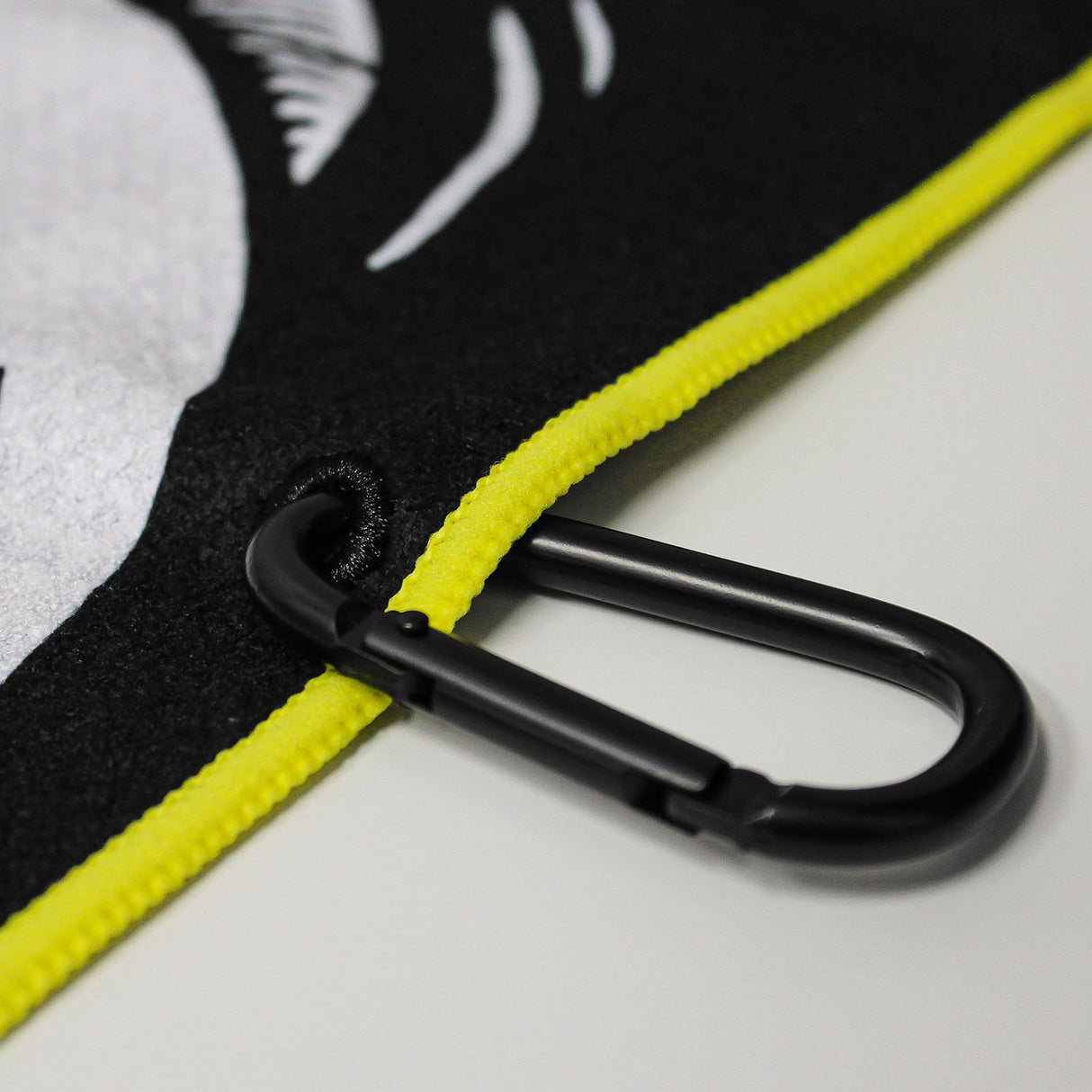 Close up of Utility Towel black carabiner clip with 'Mental Vacation' graphic