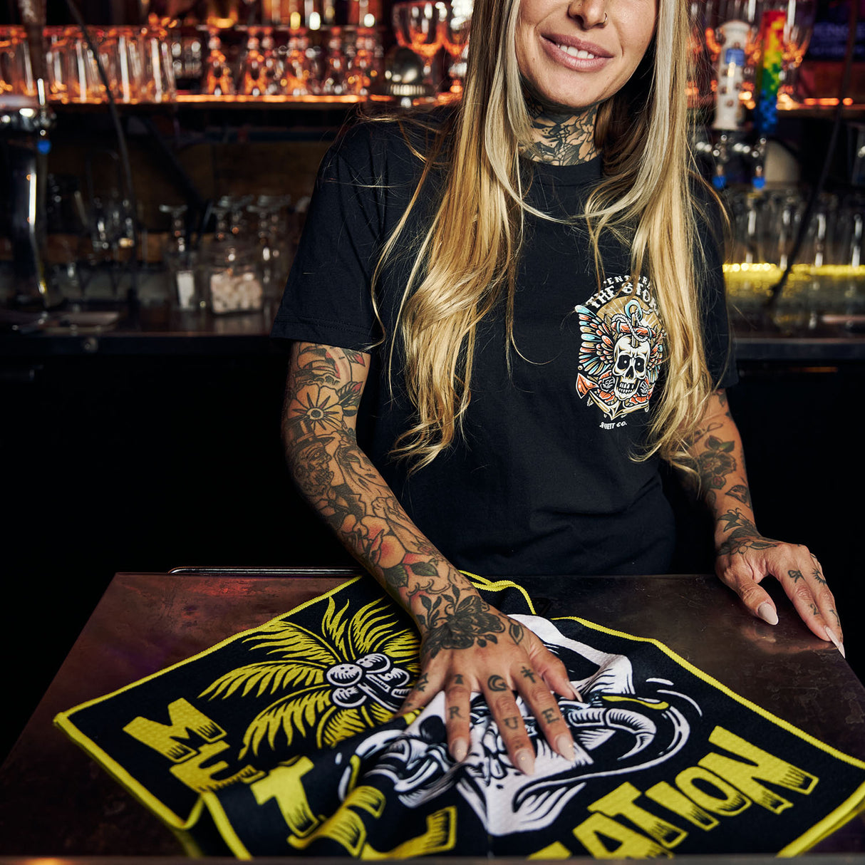 Female model using Utility Towel on bar top with 'Mental Vacation' graphic