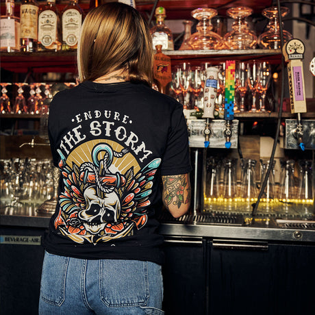 Female model in bar wearing black Active Tee with 'Endure The Storm' graphic